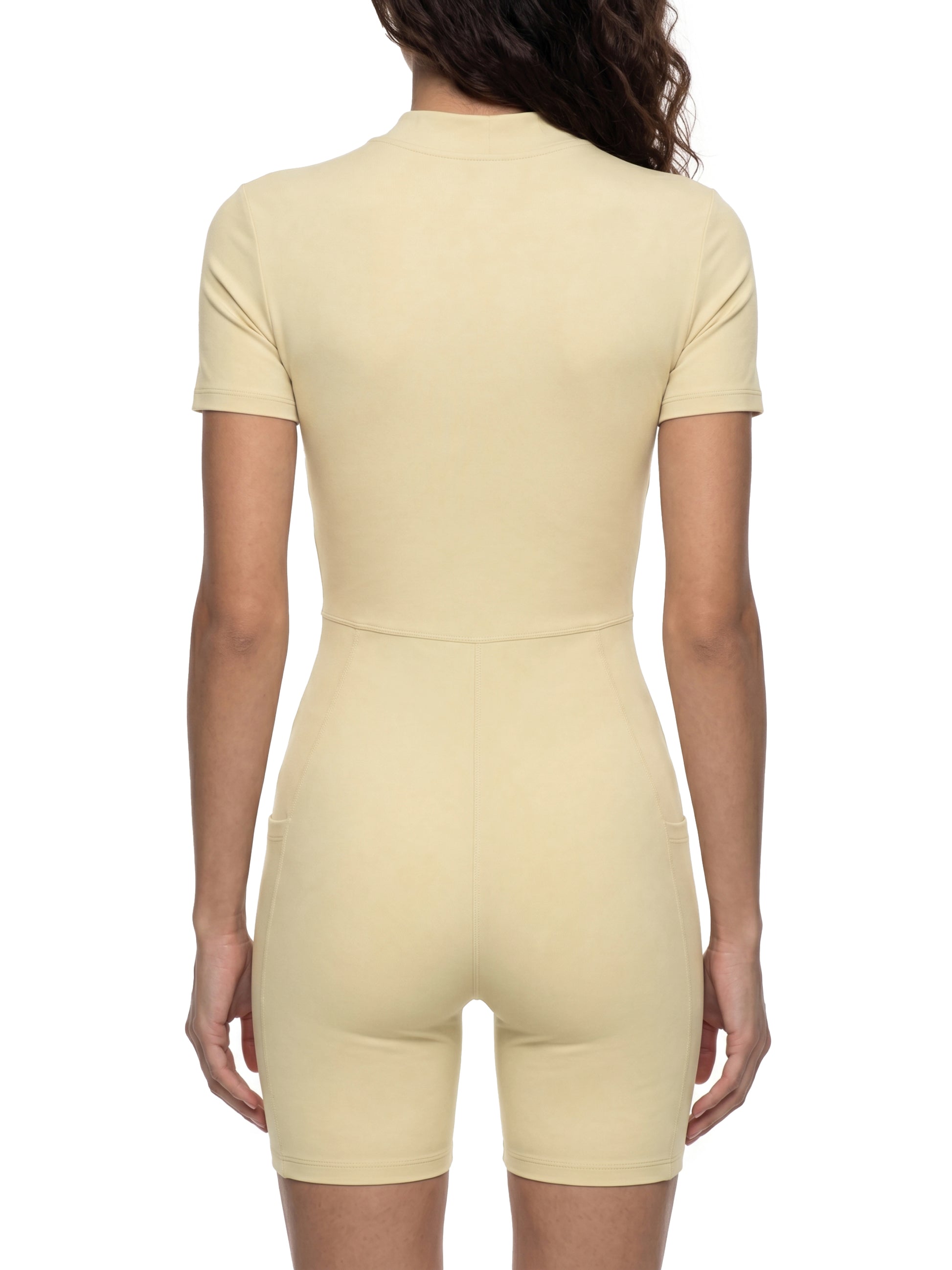 Beige bodysuit worn by a person on a white background